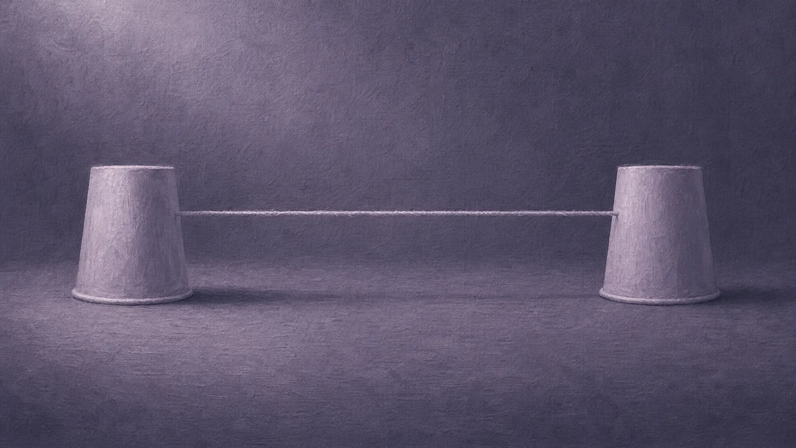 Two paper cups joined by a taut string across dusty violet paper