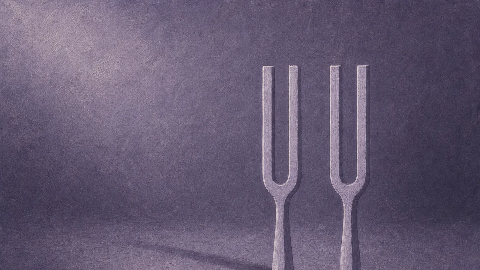 Two identical tuning forks standing upright, one casting no shadow