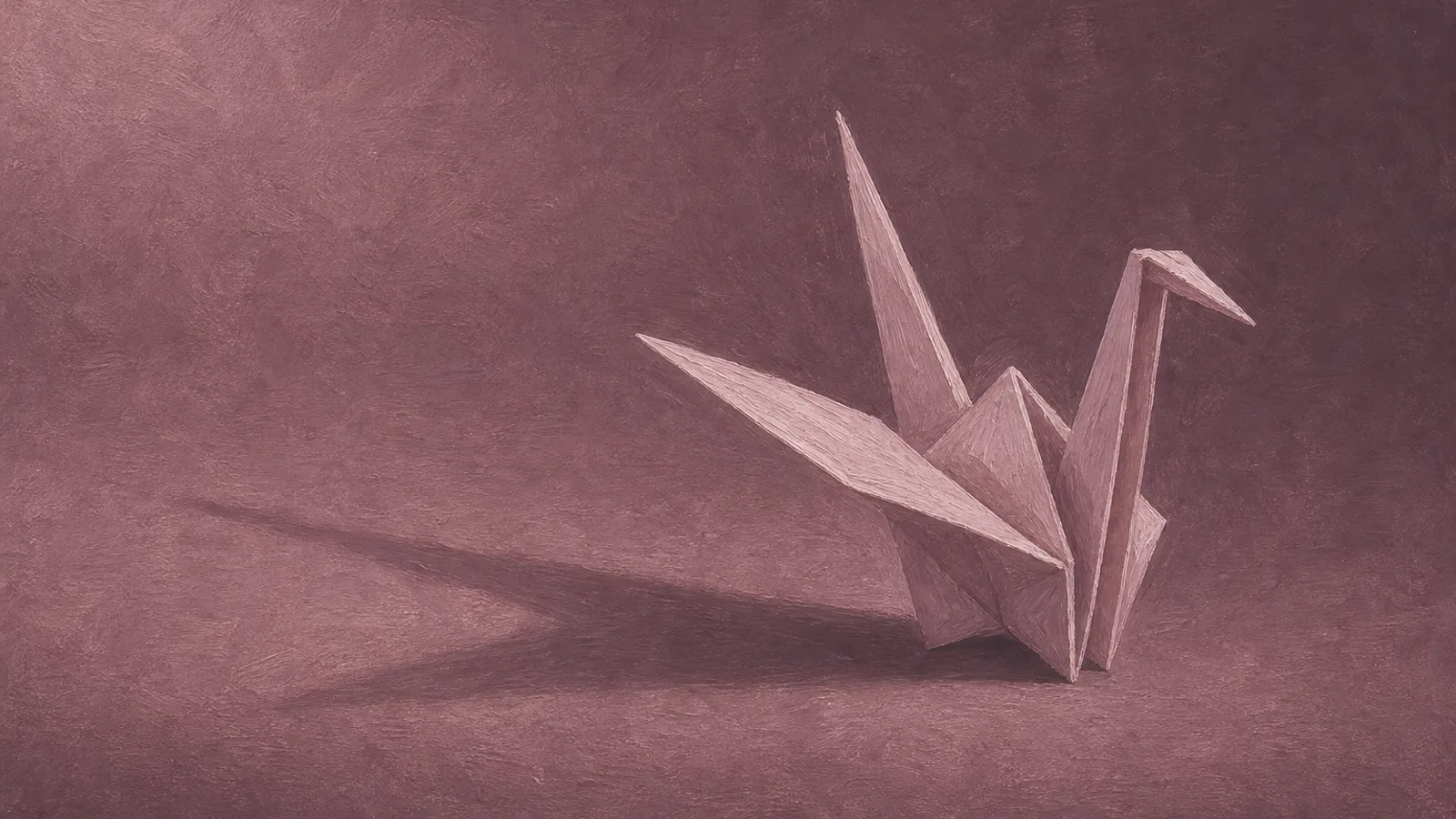A single delicate paper crane standing alone on a plain surface