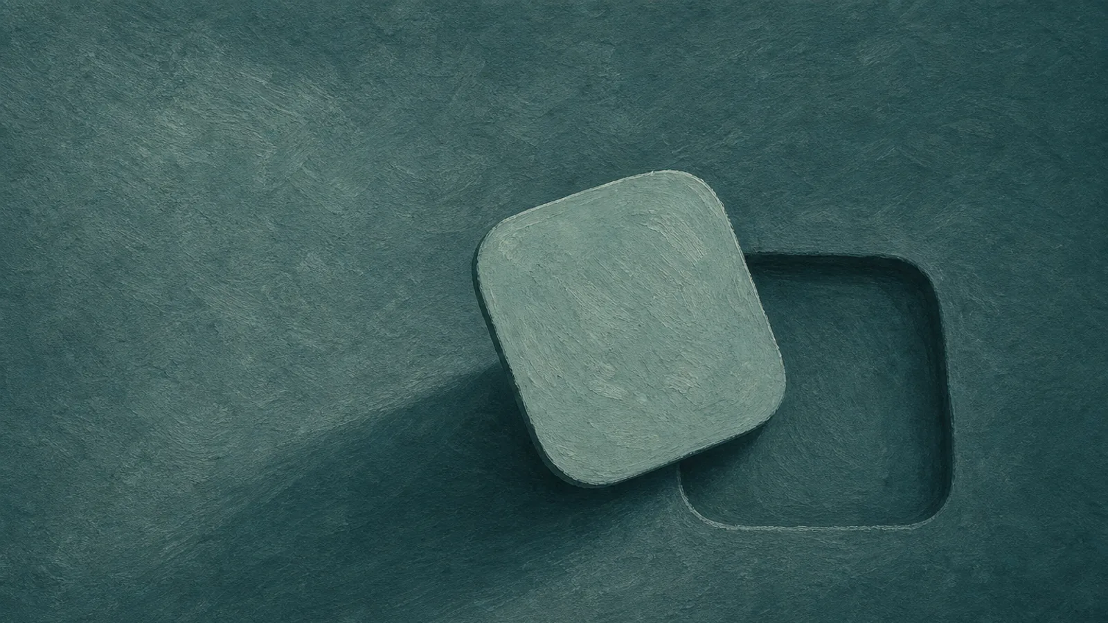 A folded-paper app tile lifted aside to show a shallow empty recess beneath it