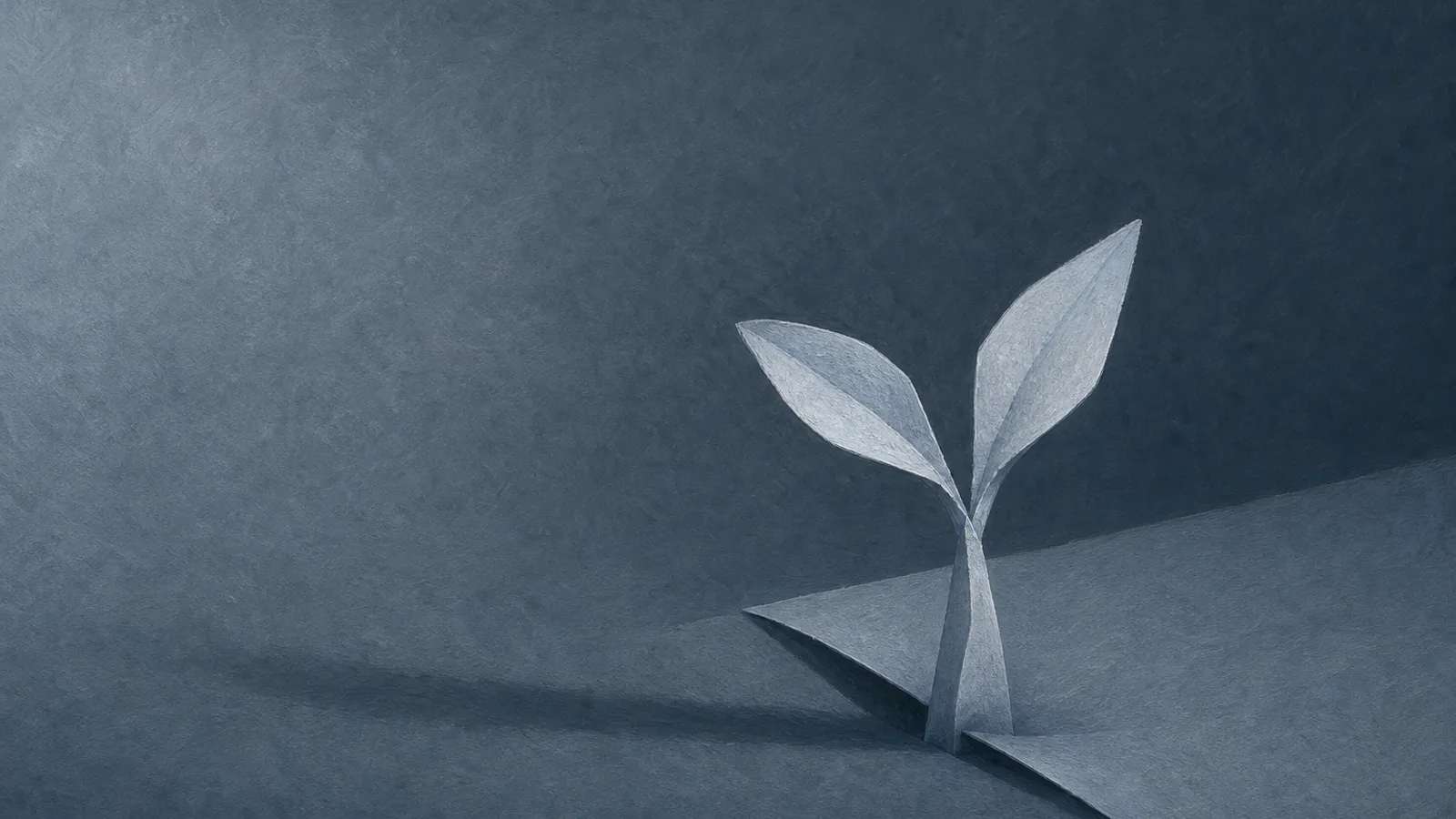 A small paper sprout rising through a fold in slate-blue paper