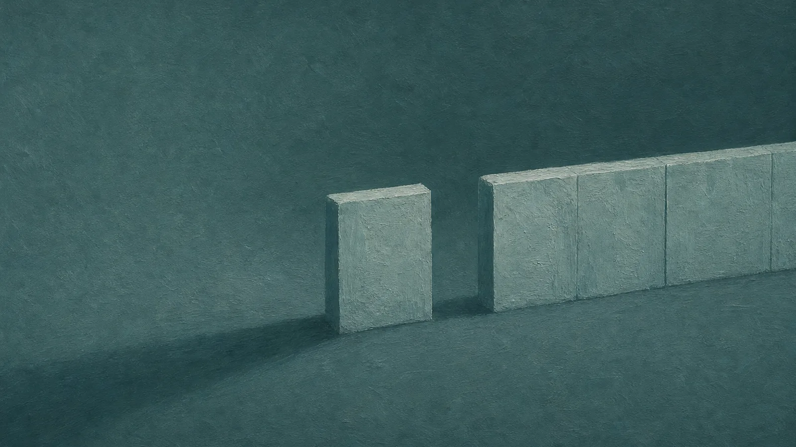 A low paper wall with a visible gap on a deep-teal surface, casting a long shadow