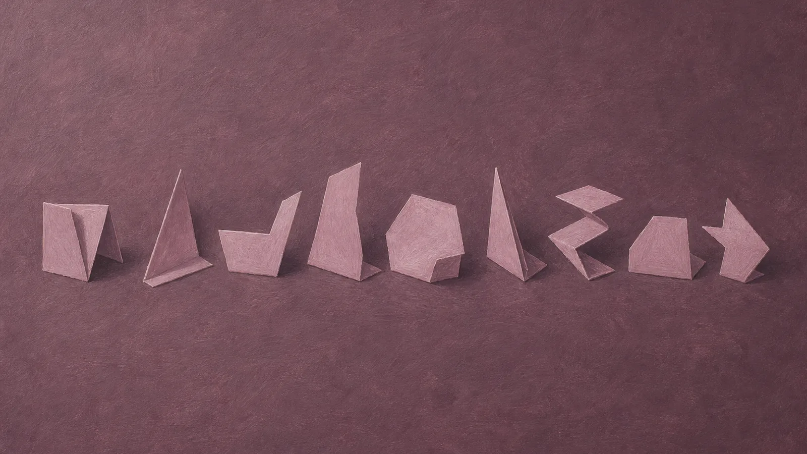 Several differently shaped paper pieces laid out together in a row on a plain surface