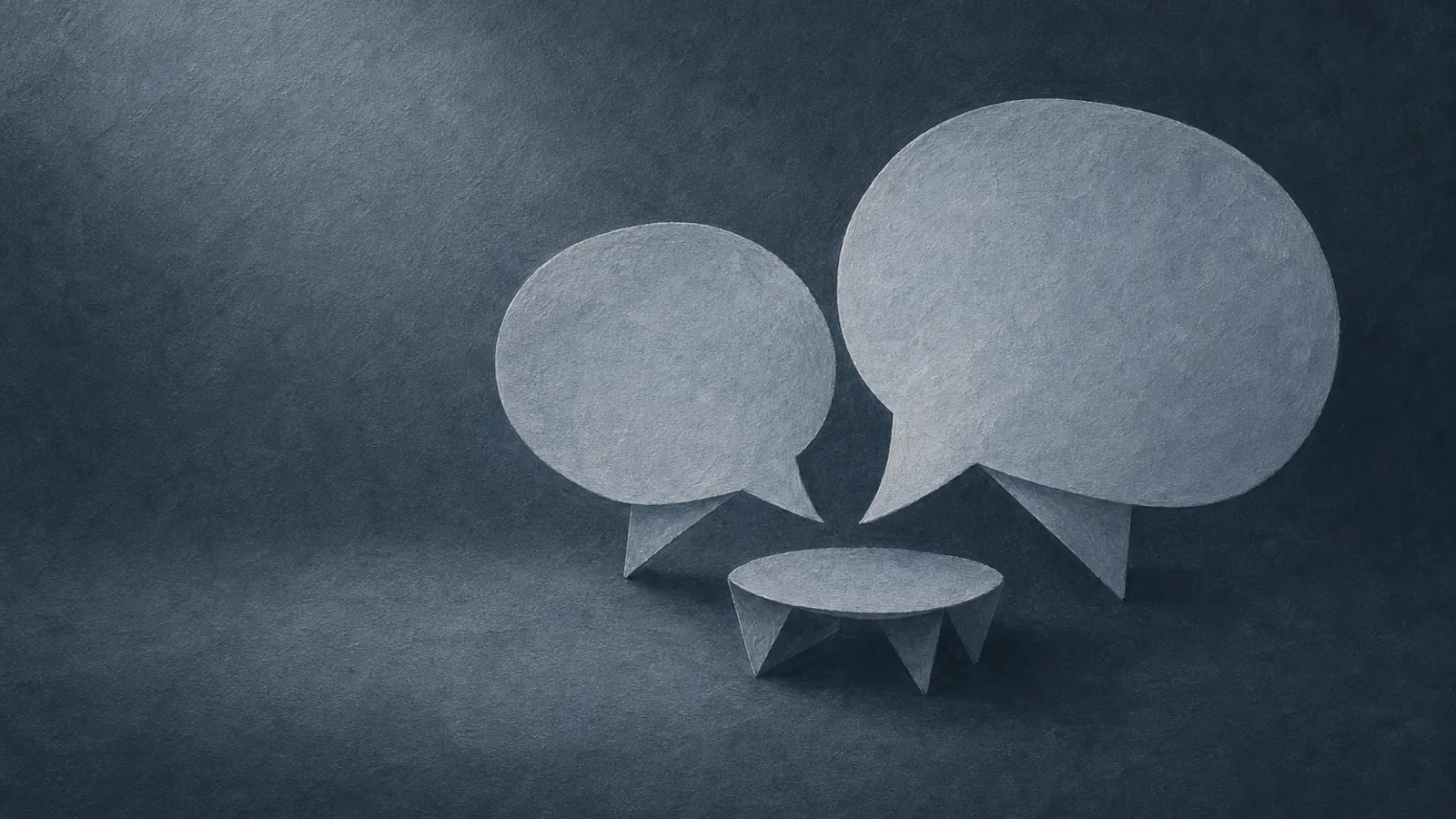 Two folded paper speech bubbles leaning gently toward each other over a small paper table